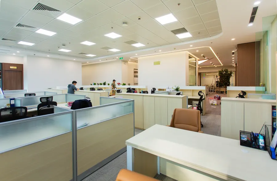 Tavanında sıralı LED panellerin bulunduğu aydınlık açık ofis